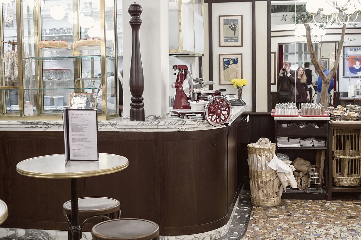 La sala del bar con il bancone in legno e i tavolini davanti alla vetrina