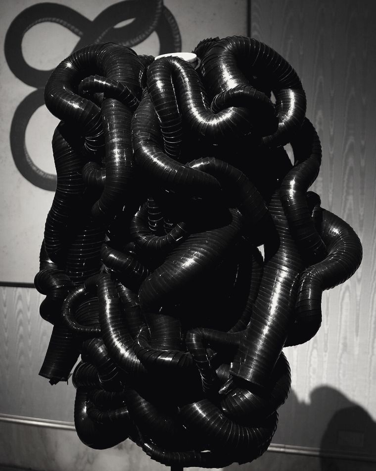 Copricapo scultoreo nero su fondo scuro